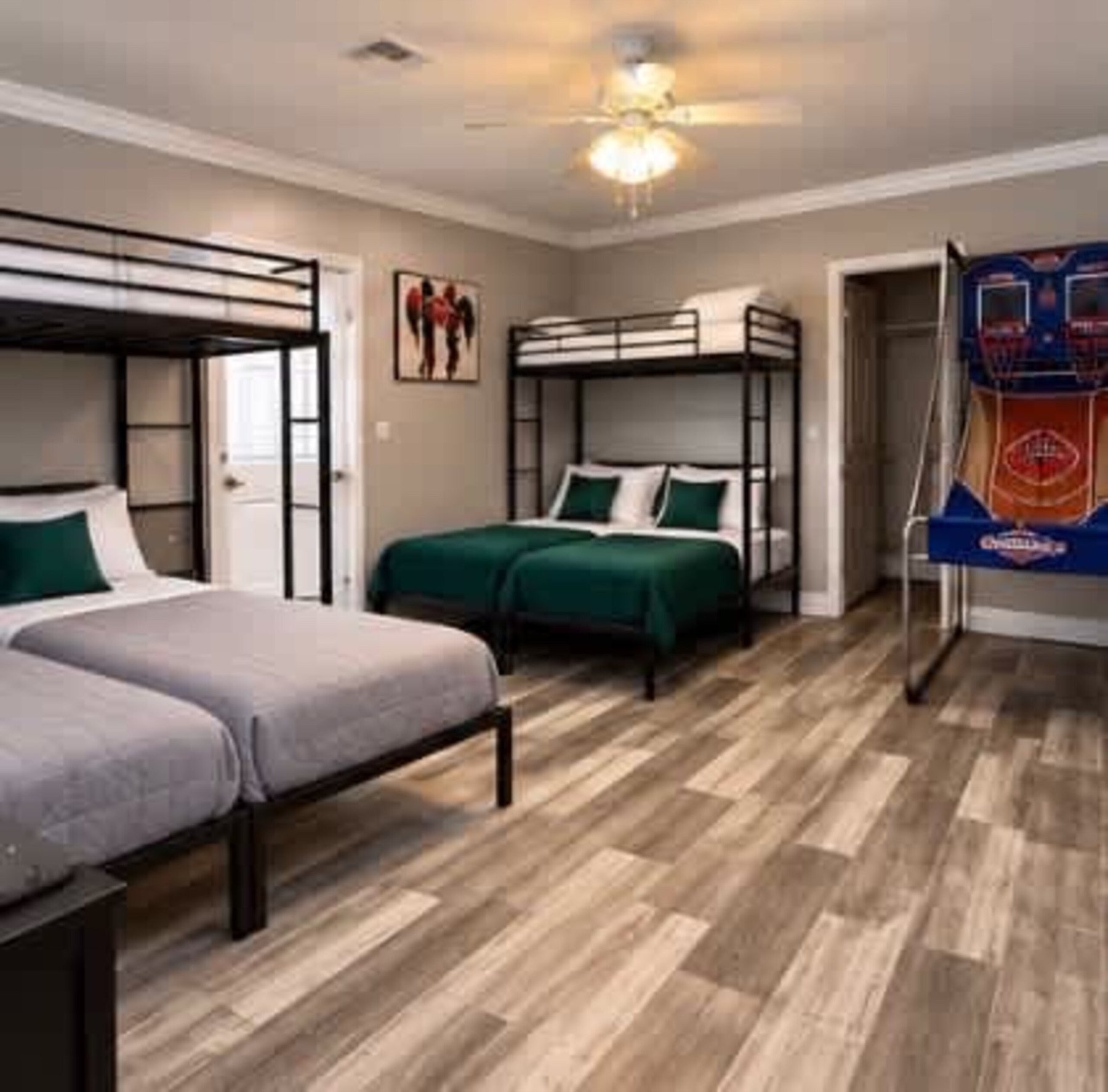 The bunk room: metal bunk frames with green and white bedding, and a two-hoop basketball arcade machine against the far wall.